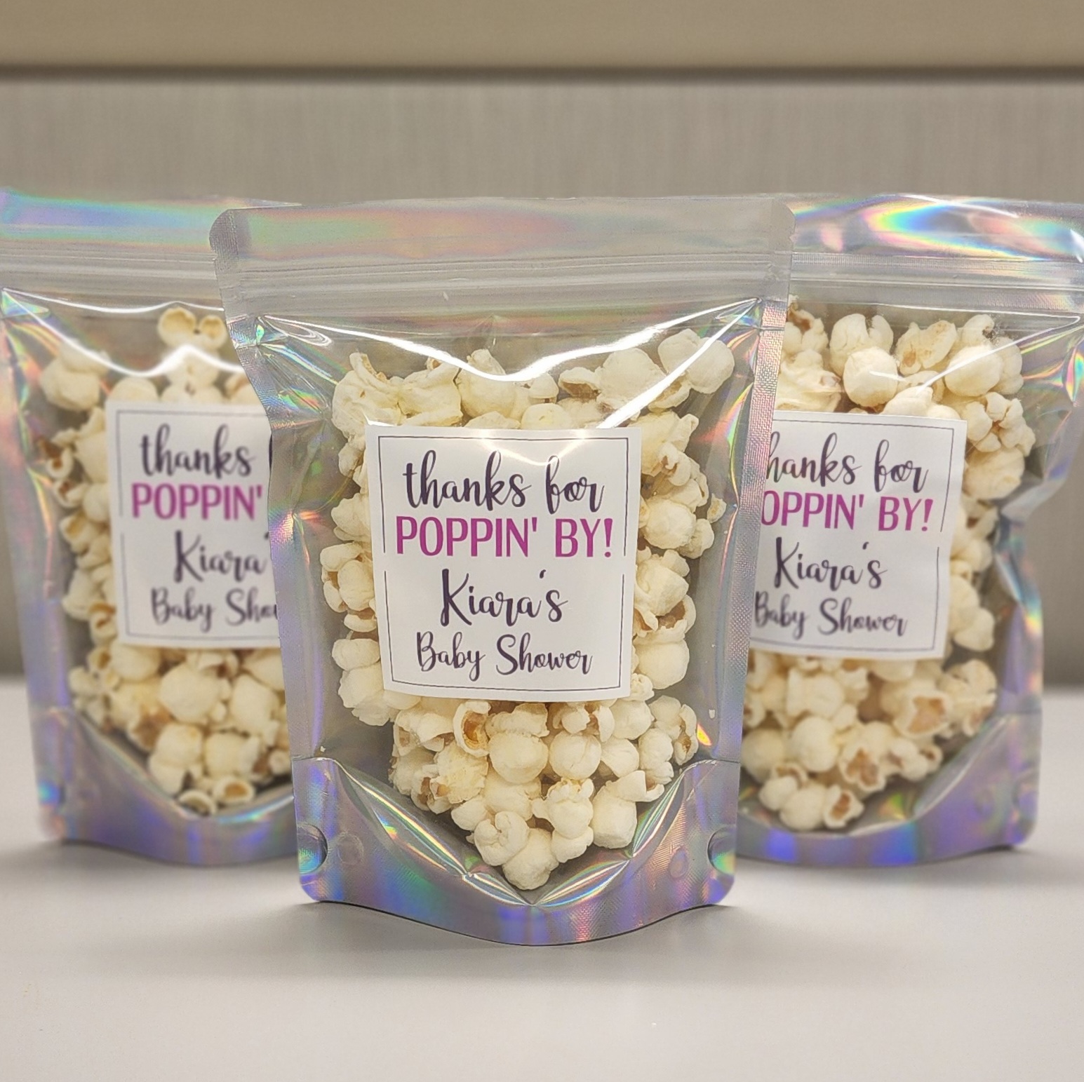 Baby Shower favors with custom designed favor tag labels that read thanks for POPPIN' BY Kiara's Baby Shower.